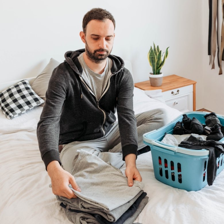 Man in recovery home folding laundry