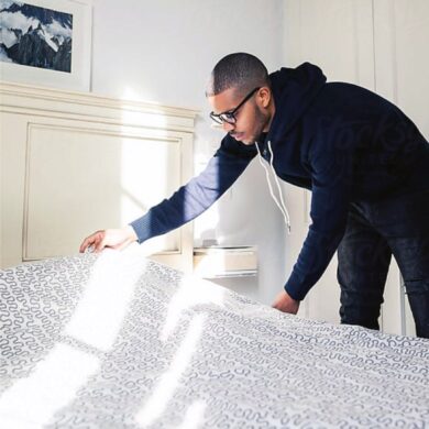 Man making his bed in recovery housing